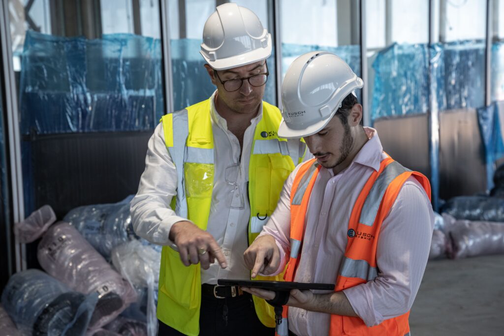 KUSCH Team Members onsite looking at a tablet
